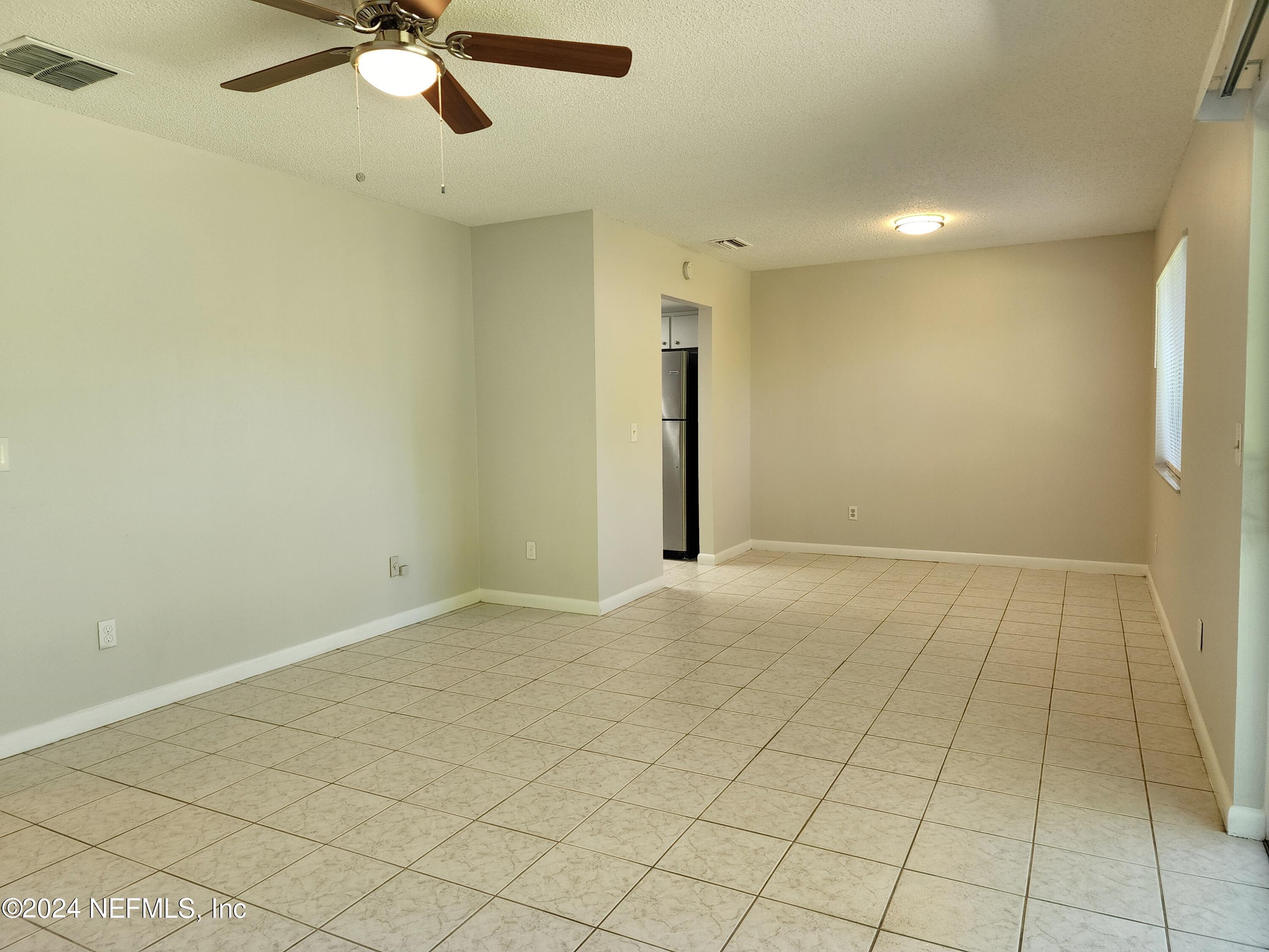 8423 Graybar Drive Jacksonville, FL 32221 - Photo 9 of 29 an empty room with a ceiling fan