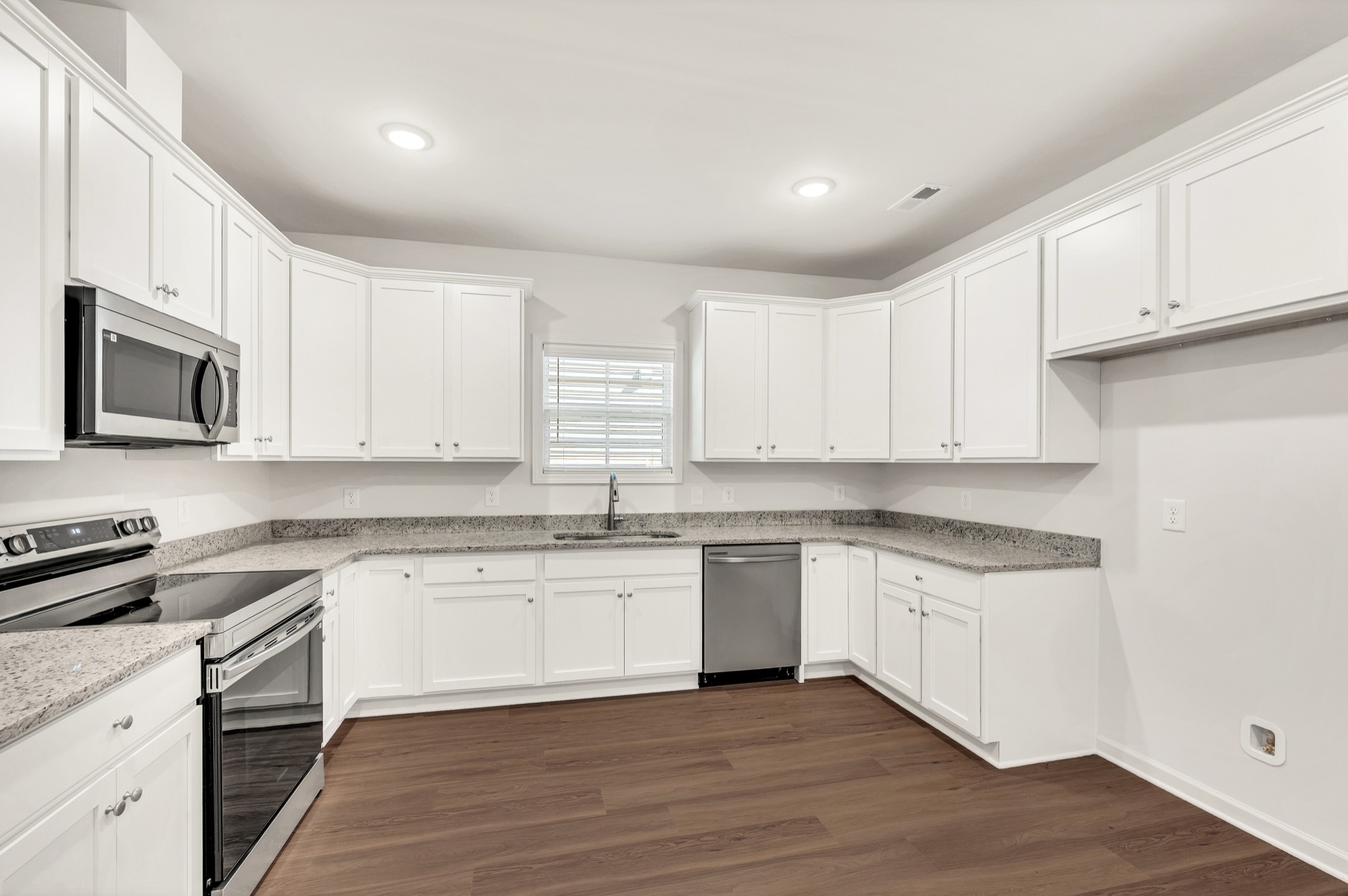 7091 Wiley Circle Fairview, TN 37062 - Photo 12 of 32 a kitchen with granite countertop white cabinets and stainless steel appliances