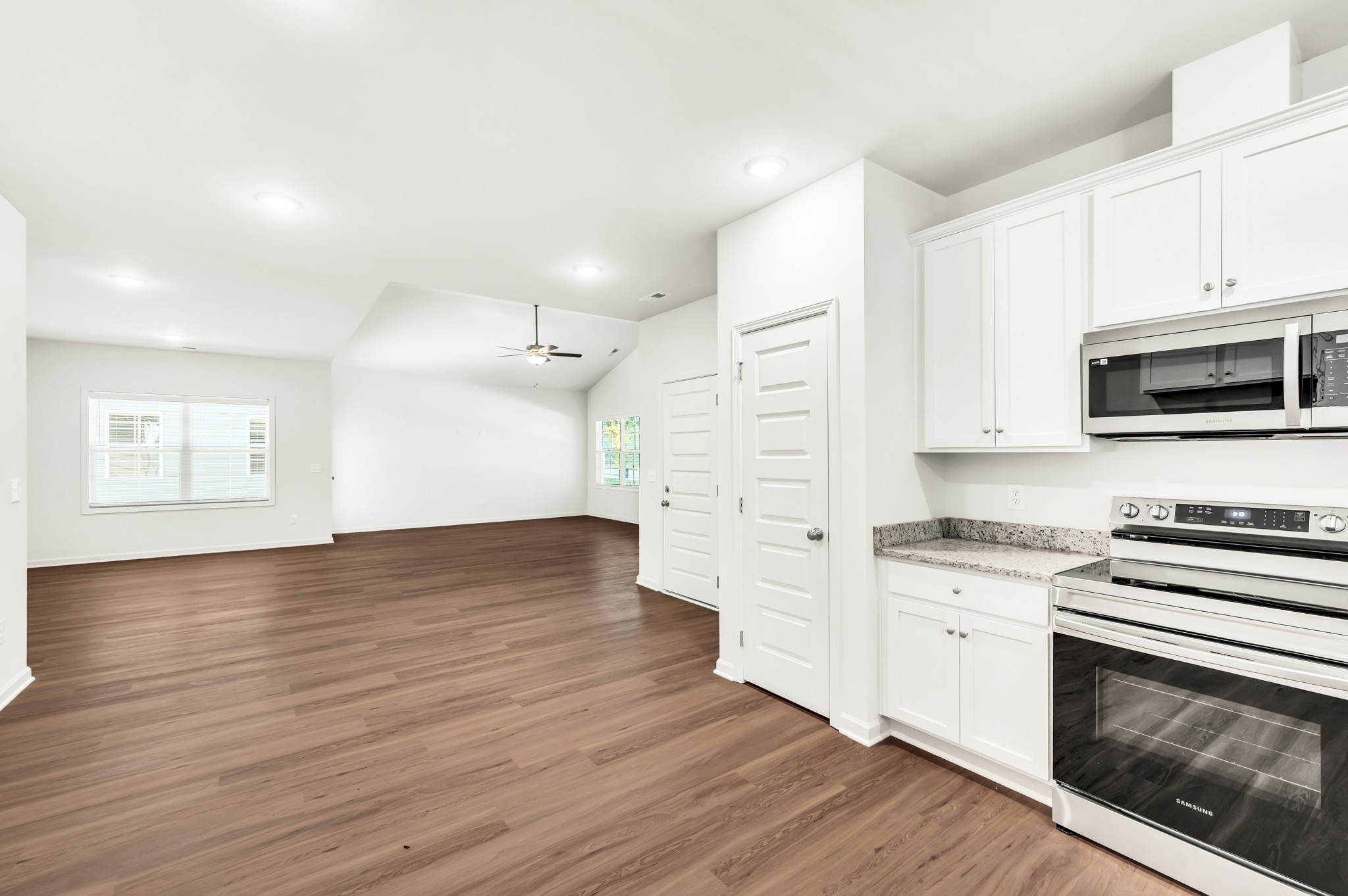 7091 Wiley Circle Fairview, TN 37062 - Photo 14 of 32 a kitchen with stainless steel appliances a white stove top oven cabinets and a wooden floor