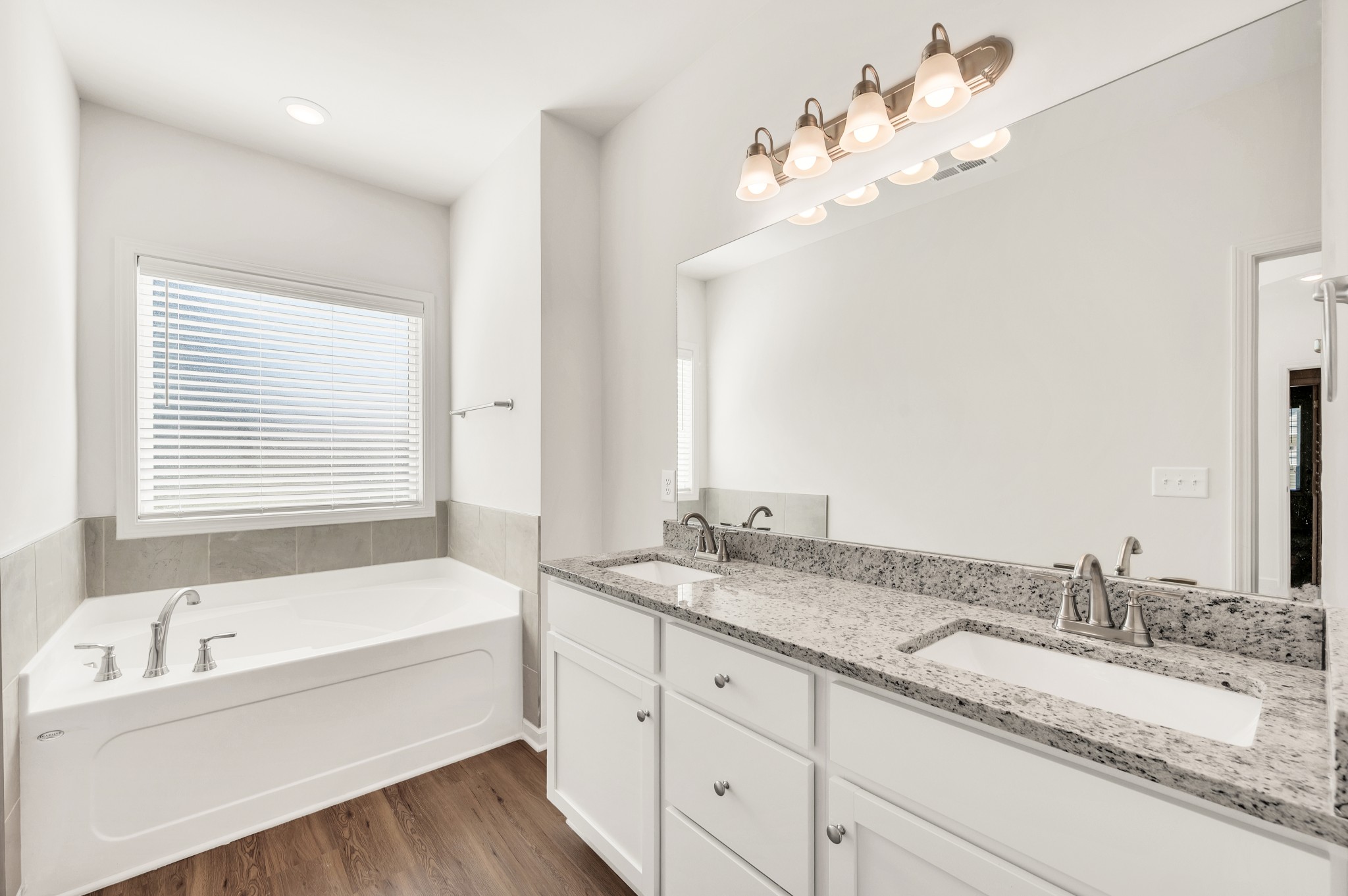 7091 Wiley Circle Fairview, TN 37062 - Photo 24 of 32 a bathroom with a granite countertop bathtub a sink and a large mirror