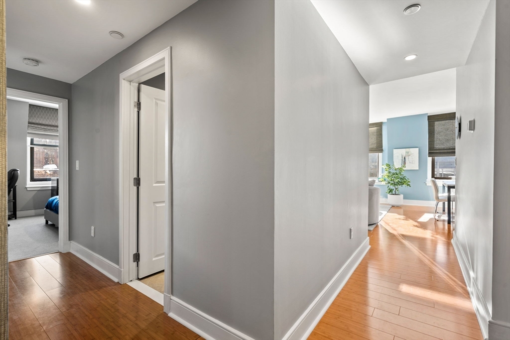 201 Newbury Street, Unit 405 Boston, MA 02116 - Photo 12 of 17 a view of a hallway with wooden floor and a living room