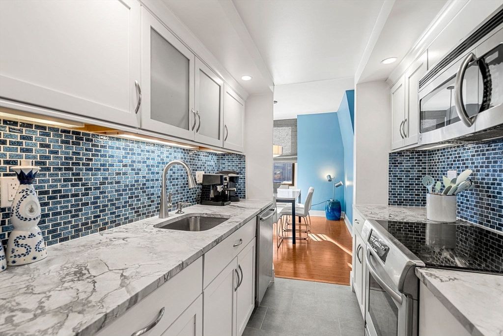 201 Newbury Street, Unit 405 Boston, MA 02116 - Photo 5 of 17 a kitchen with stainless steel appliances granite countertop a sink stove and cabinets