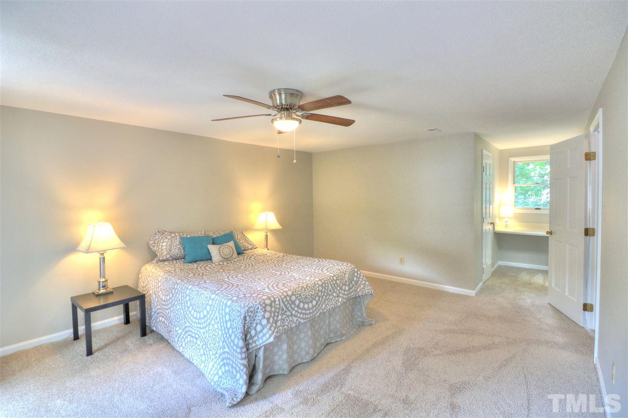 1909 Summerlyn Court Raleigh, NC 27609 - Photo 12 of 24 a bedroom with a bed and a chandelier
