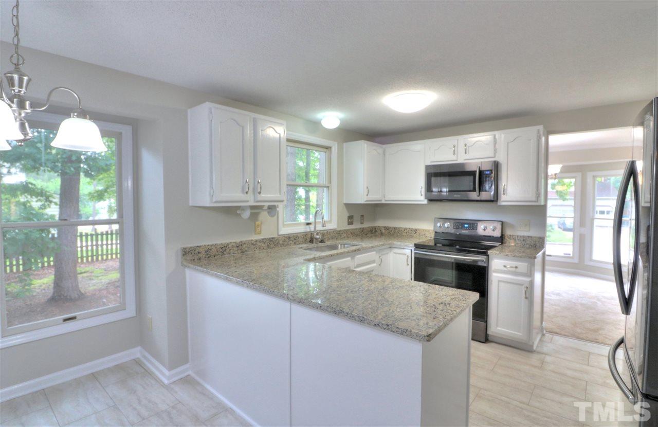 1909 Summerlyn Court Raleigh, NC 27609 - Photo 5 of 24 a kitchen with kitchen island granite countertop a stove sink and microwave