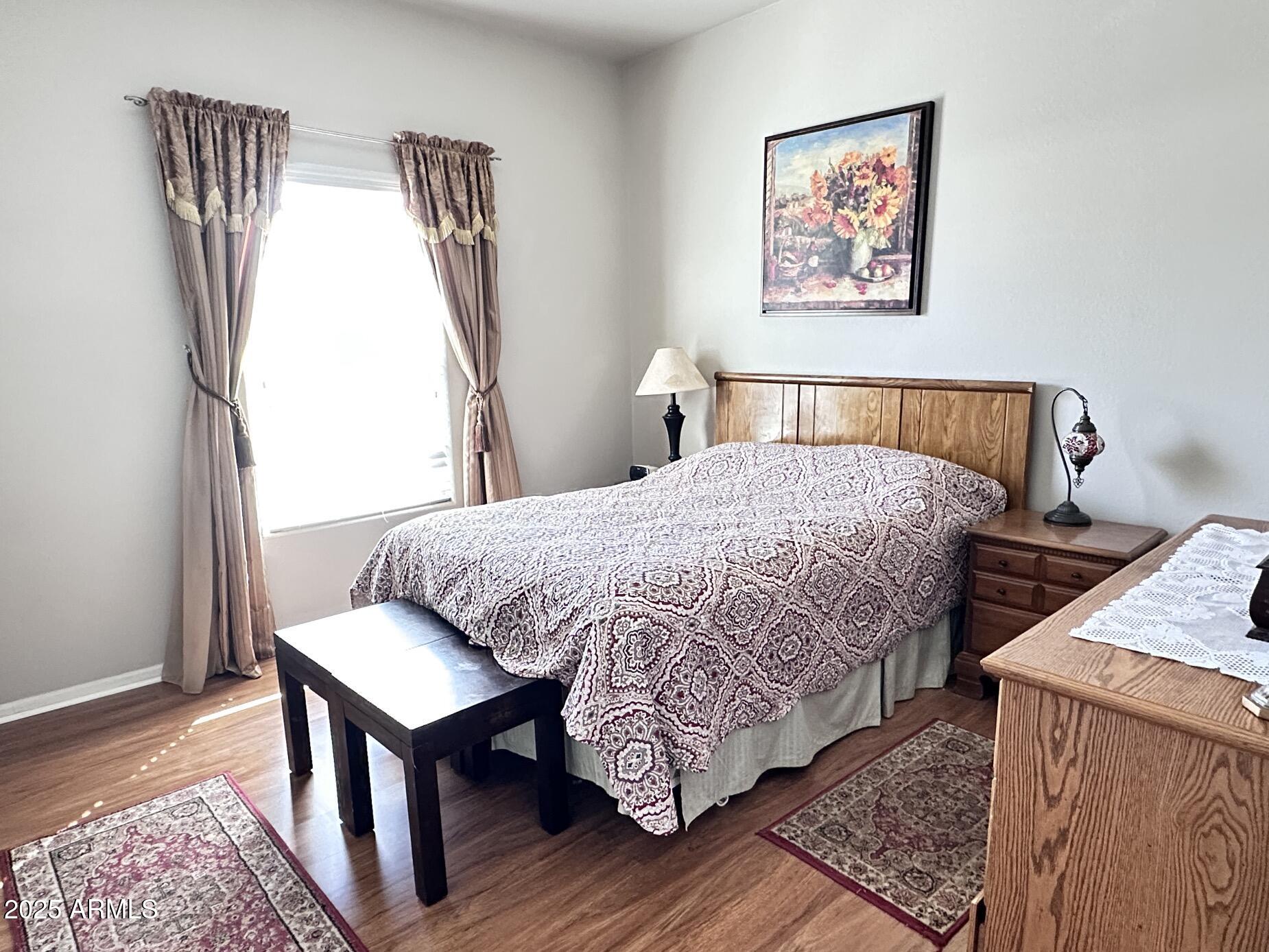 2000 South Apache Road, Unit 126 Buckeye, AZ 85326 - Photo 13 of 29 a bedroom with a bed and wooden floor