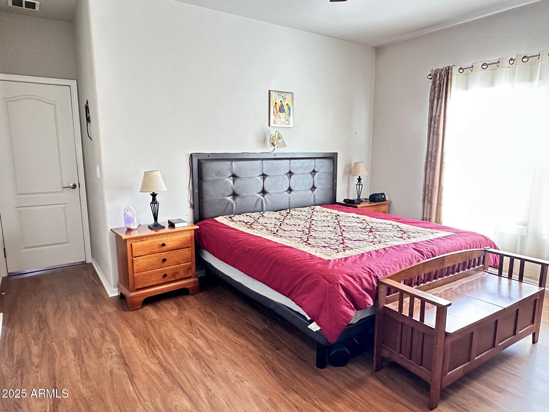 2000 South Apache Road, Unit 126 Buckeye, AZ 85326 - Photo 15 of 29 a bedroom with a bed and wooden floor