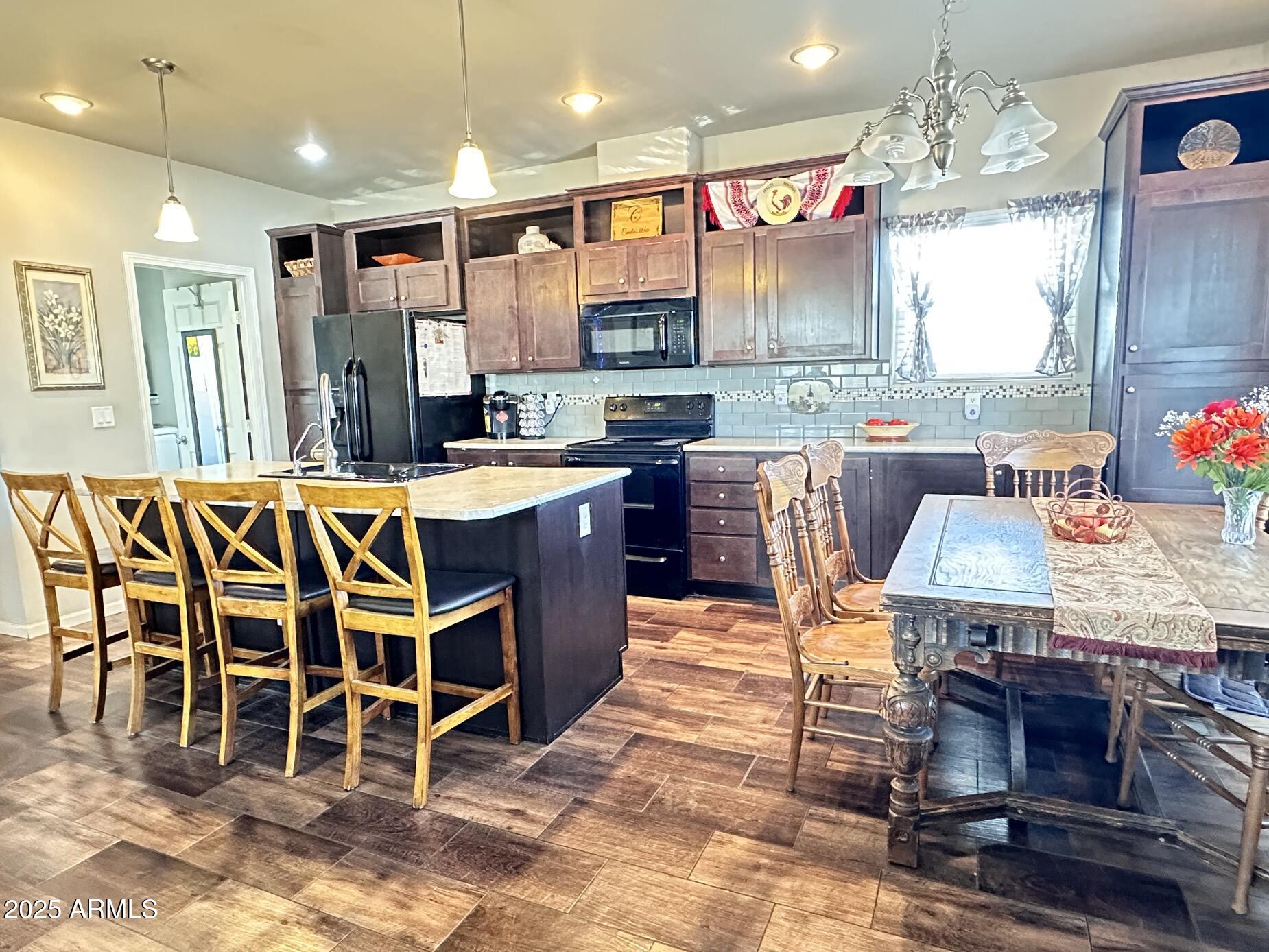 2000 South Apache Road, Unit 126 Buckeye, AZ 85326 - Photo 6 of 29 a kitchen with stainless steel appliances kitchen island granite countertop a table chairs and a refrigerator