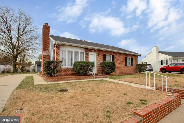 a front view of a house with a yard and potted plants