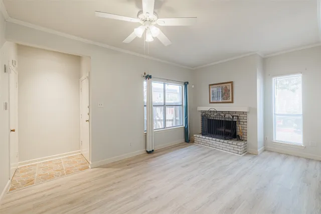 wooden floor fireplace and windows in an empty room