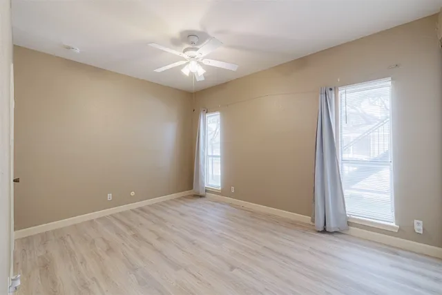 a view of an empty room with wooden floor
