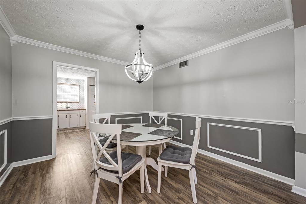4224 Lake Underhill Road, Unit 8B5 Orlando, FL 32803 - Photo 7 of 40 a view of a dining room with furniture wooden floor and chandelier