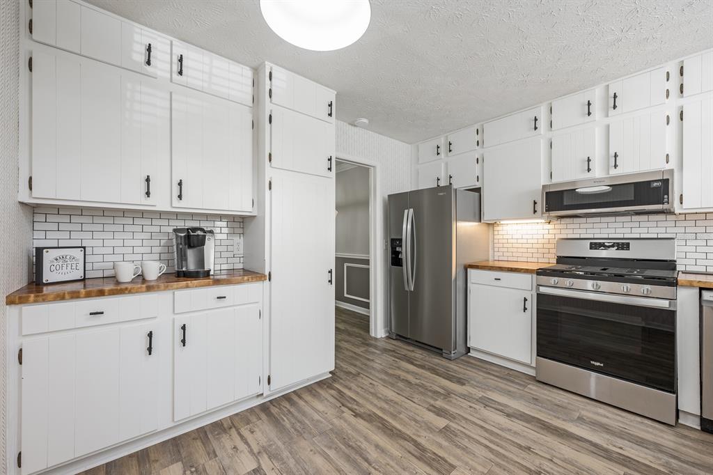 4224 Lake Underhill Road, Unit 8B5 Orlando, FL 32803 - Photo 8 of 40 a kitchen with granite countertop a refrigerator stove and white cabinets