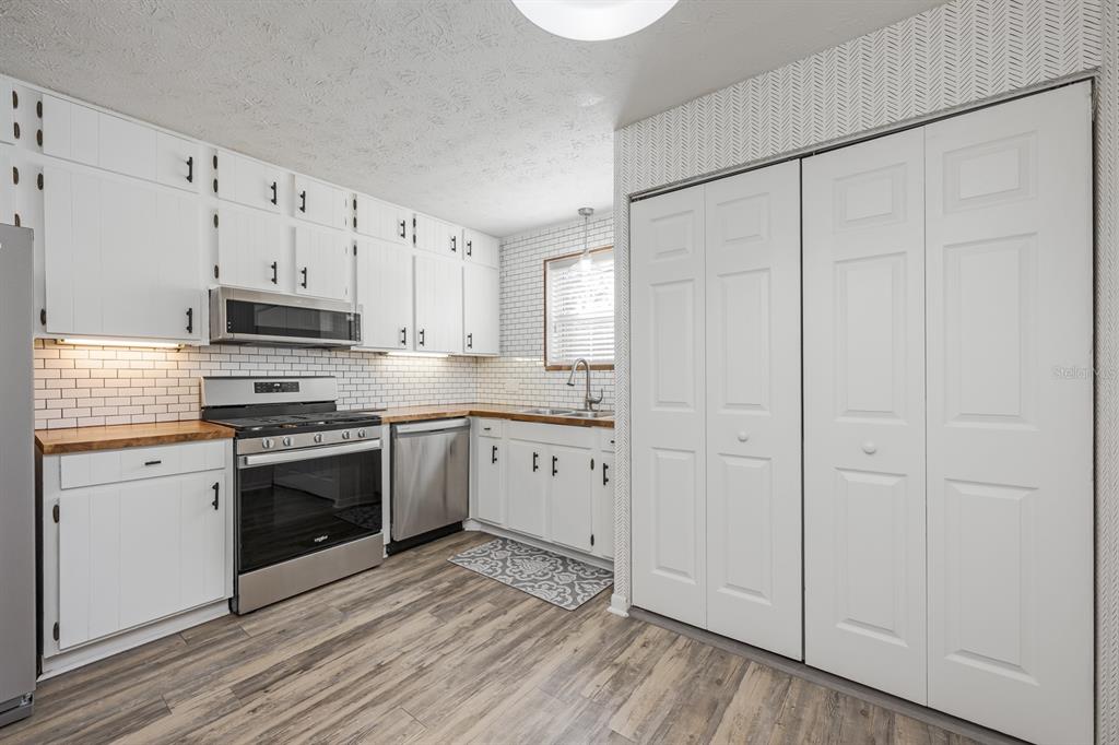 4224 Lake Underhill Road, Unit 8B5 Orlando, FL 32803 - Photo 10 of 40 a kitchen with granite countertop white cabinets and stainless steel appliances