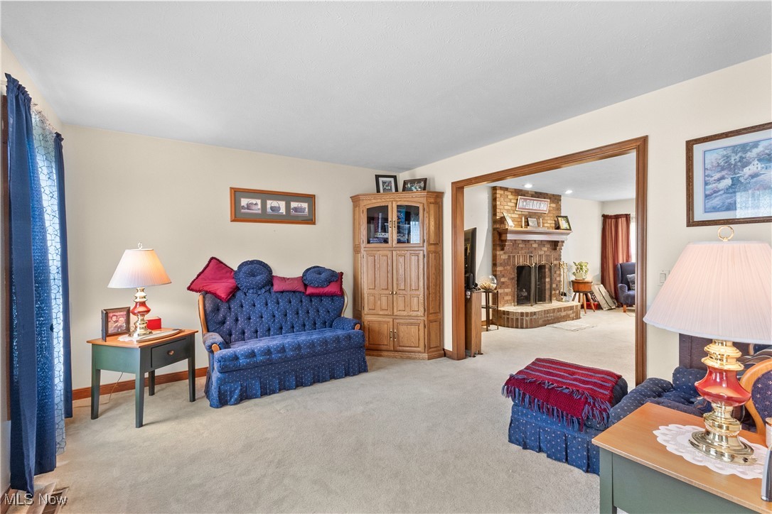 7665 Brakeman Road Painesville, OH 44077 - Photo 7 of 34 Living area featuring light carpet and a brick fireplace
