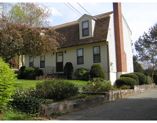 a front view of a house with a yard and potted plants