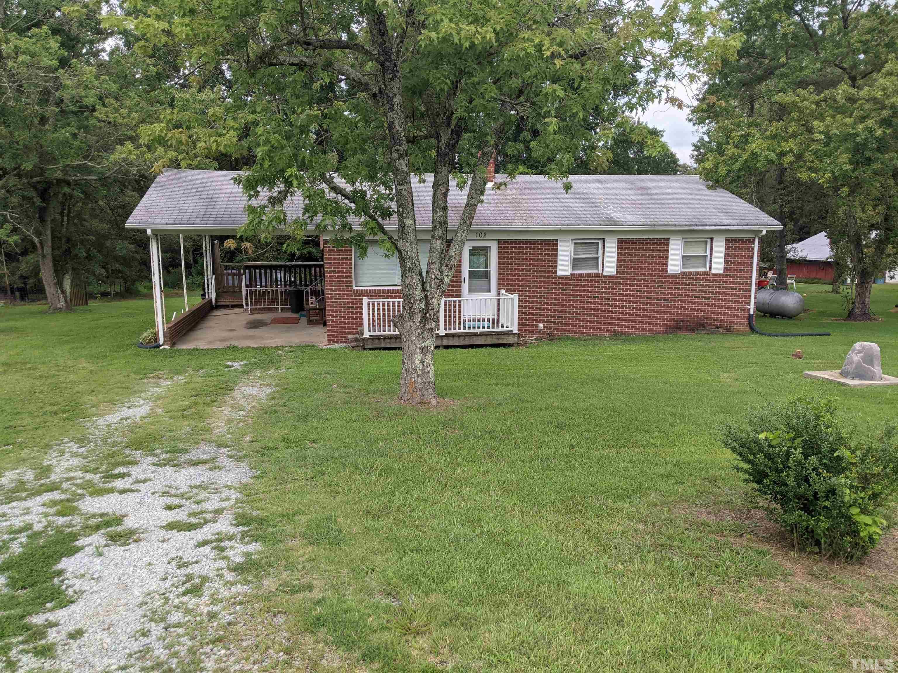 102 Dee Long Road Roxboro, NC 27574 - Photo 2 of 21 a front view of a house with a garden and trees