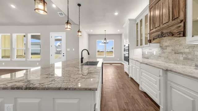 a large kitchen with kitchen island a large counter space a sink appliances and cabinets