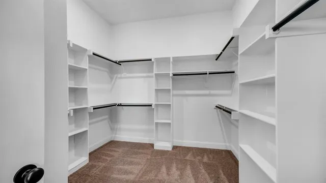 a view of walk in closet with empty racks