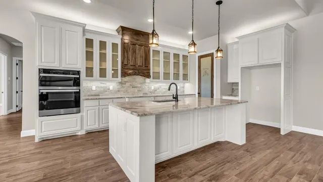 a kitchen with stainless steel appliances granite countertop a sink and a refrigerator