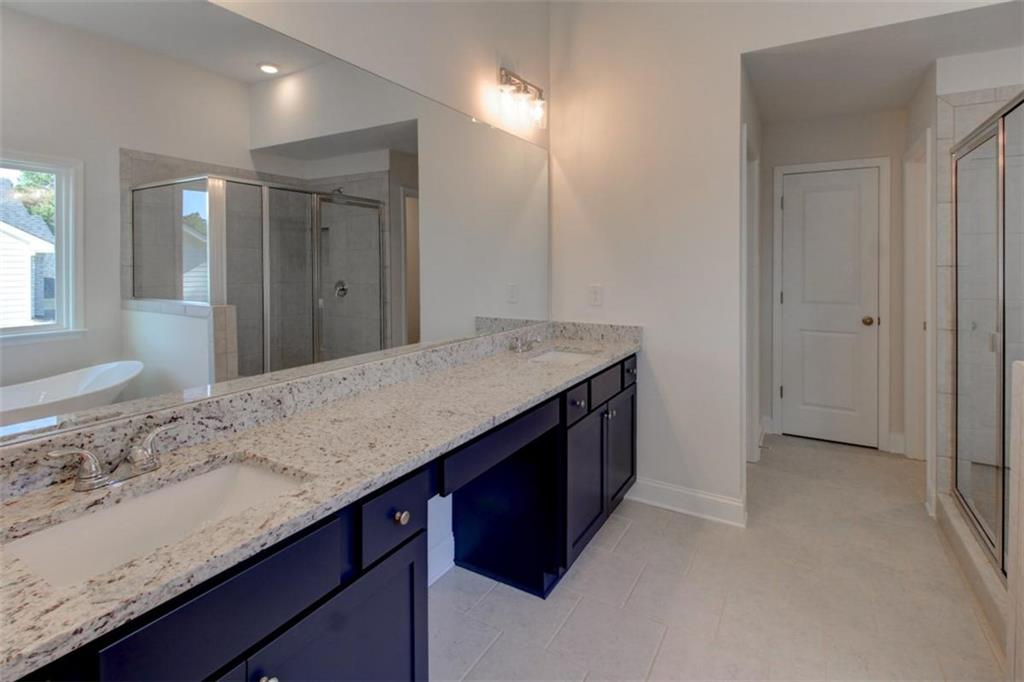 41 Woodland Road Covington, GA 30016 - Photo 37 of 46 a bathroom with a granite countertop sink a vanity and a mirror