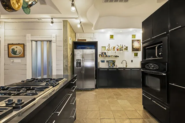 a kitchen with stainless steel appliances granite countertop a refrigerator and a stove