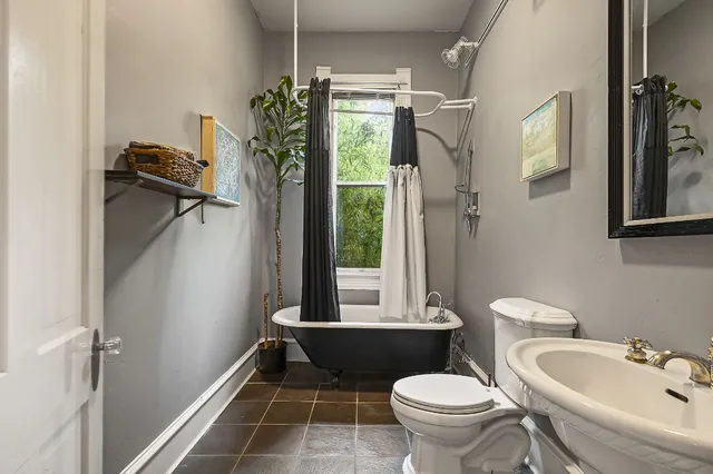 a bathroom with a toilet sink and mirror