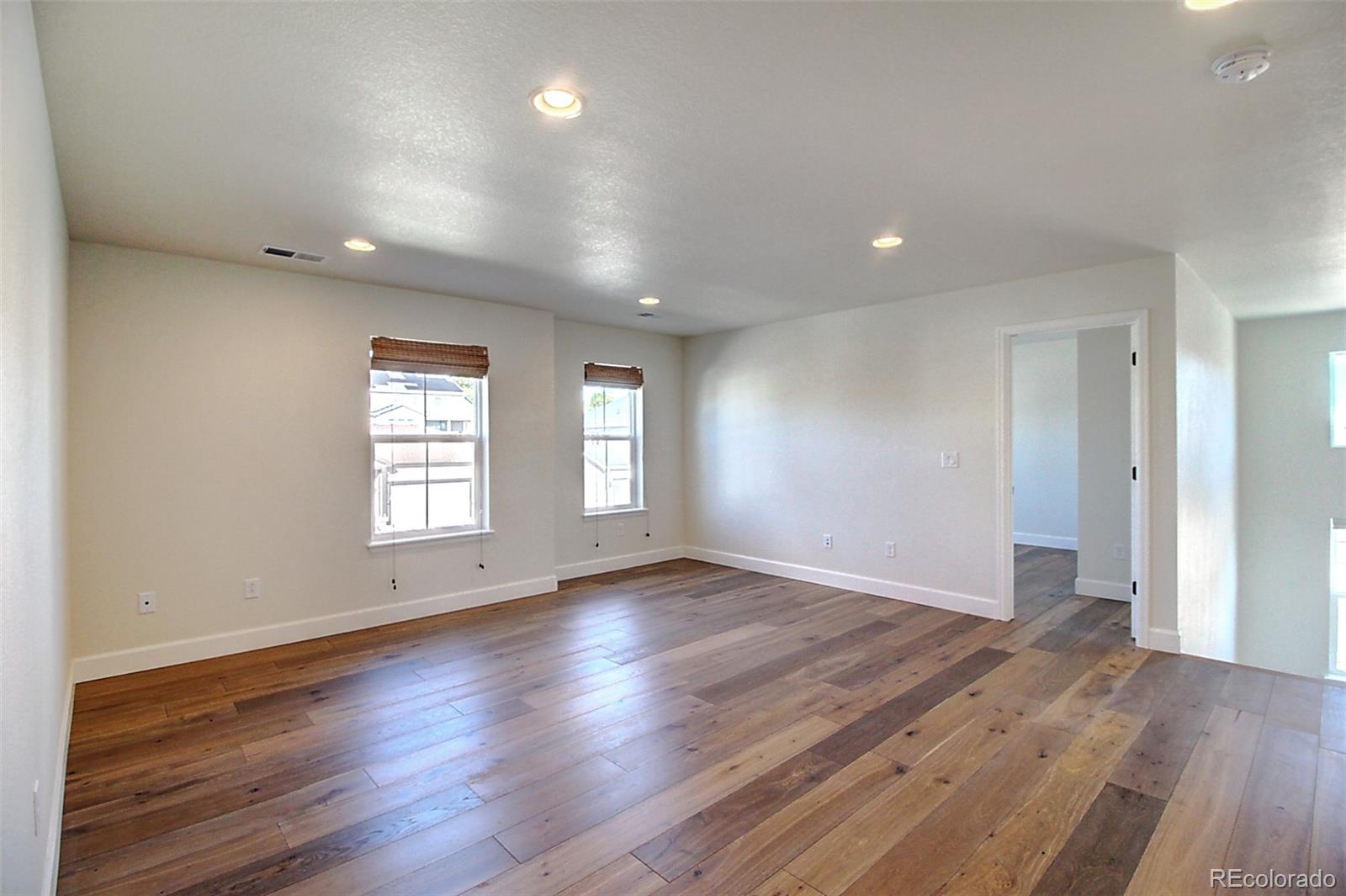 1013 Gabriella Lane Berthoud, CO 80513 - Photo 21 of 39 an empty room with wooden floor and windows