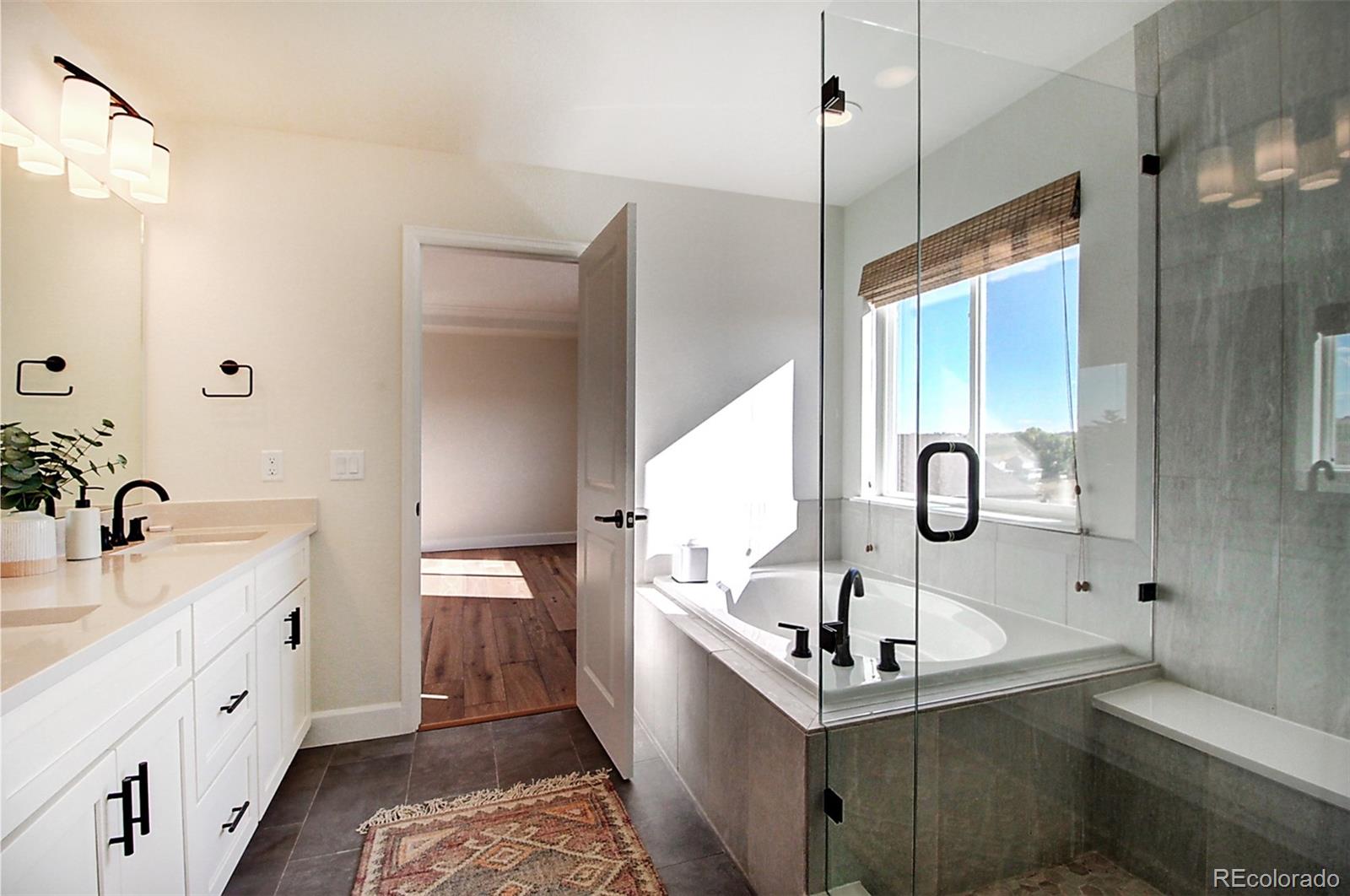 1013 Gabriella Lane Berthoud, CO 80513 - Photo 24 of 39 a bathroom with a tub sink and mirror