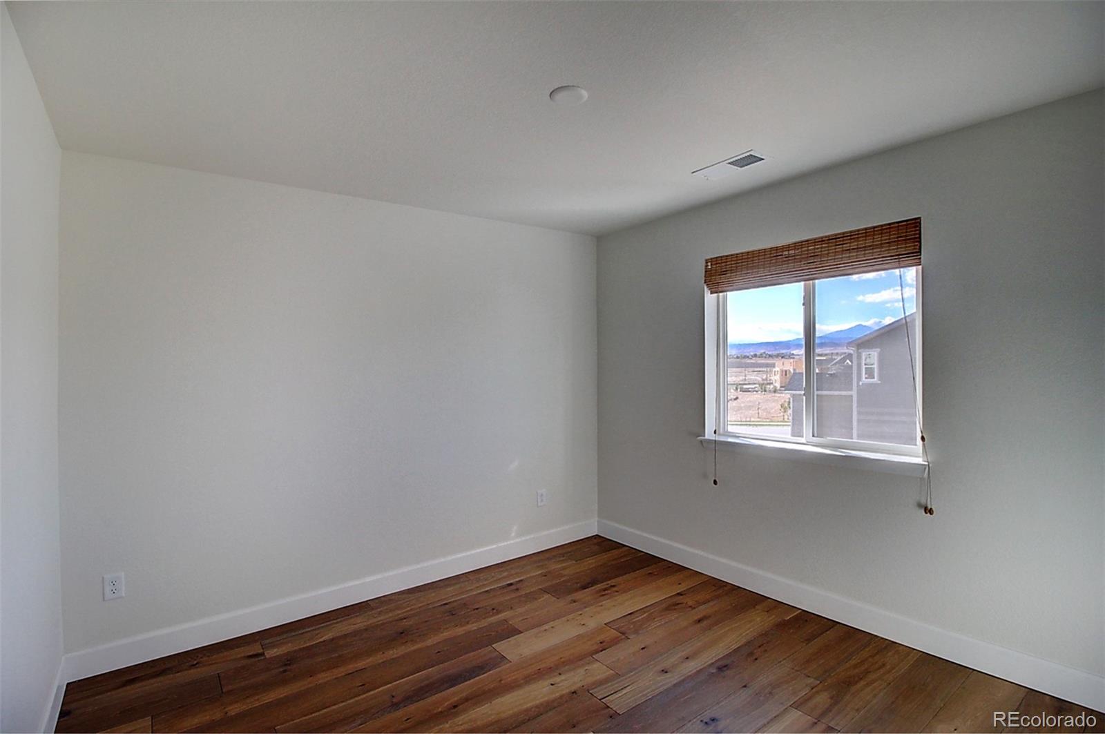 1013 Gabriella Lane Berthoud, CO 80513 - Photo 28 of 39 a view of an empty room with wooden floor and a window