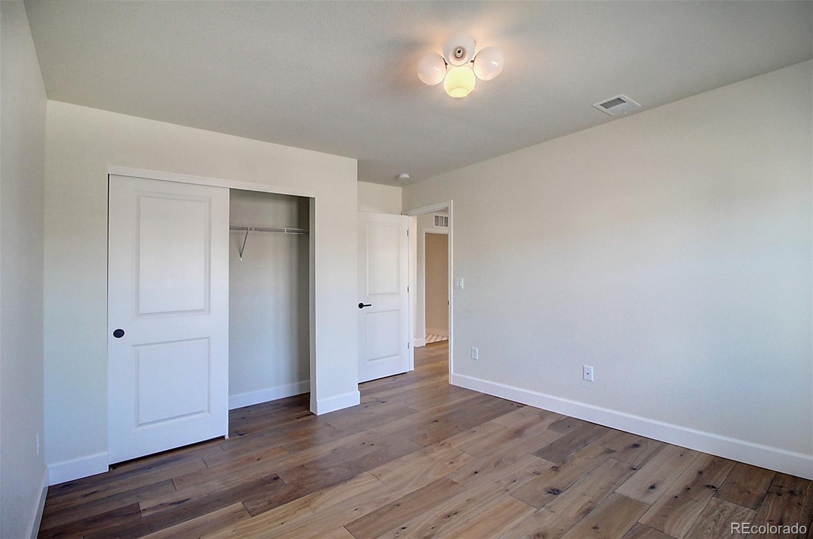 1013 Gabriella Lane Berthoud, CO 80513 - Photo 29 of 39 a view of an empty room with wooden floor and closet