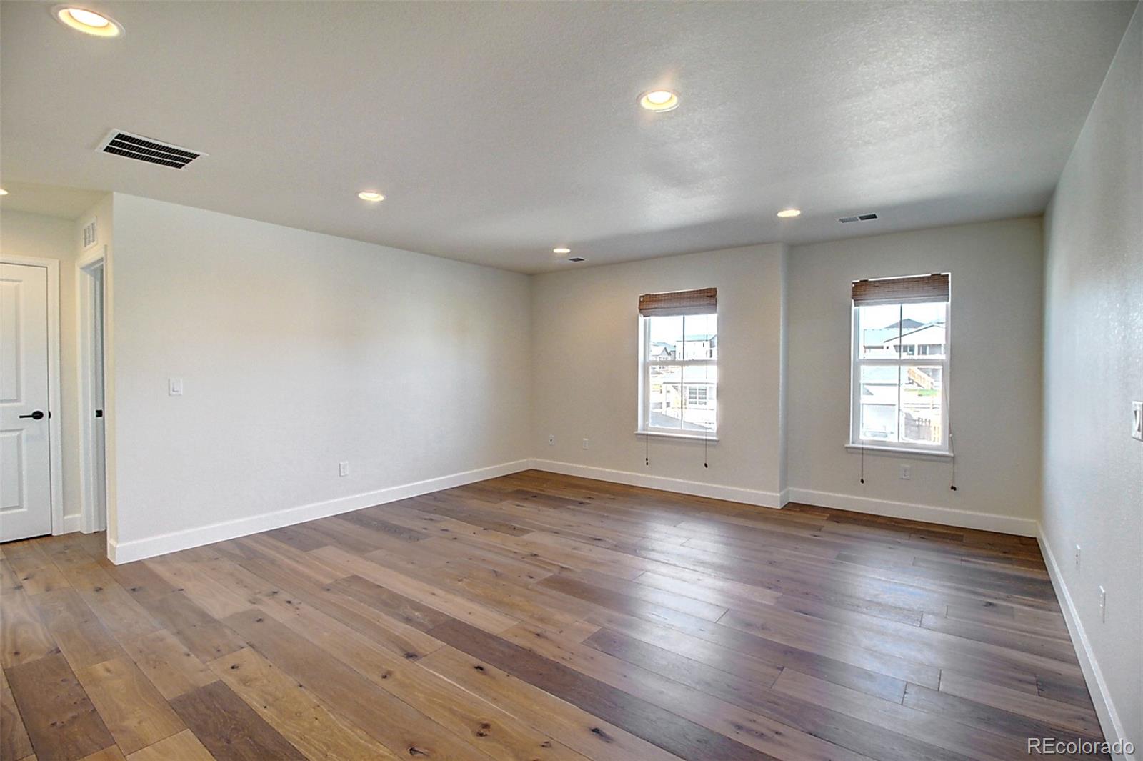 1013 Gabriella Lane Berthoud, CO 80513 - Photo 30 of 39 an empty room with wooden floor and windows