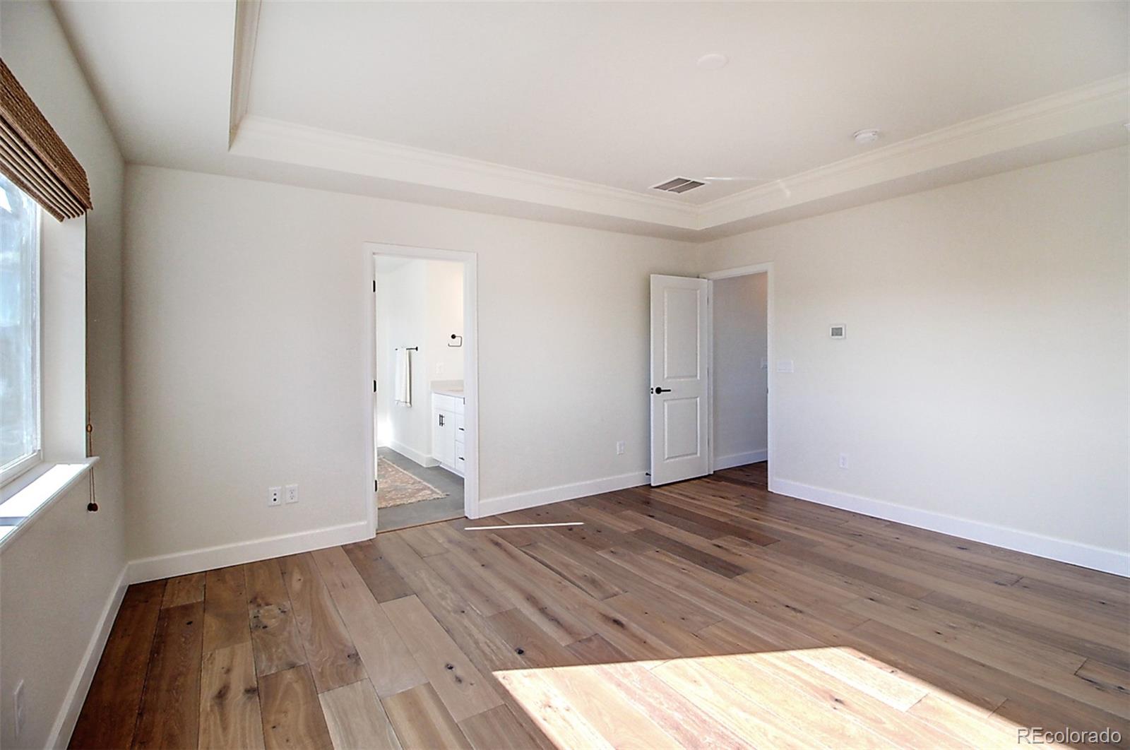 1013 Gabriella Lane Berthoud, CO 80513 - Photo 32 of 39 a view of an empty room with wooden floor and a window