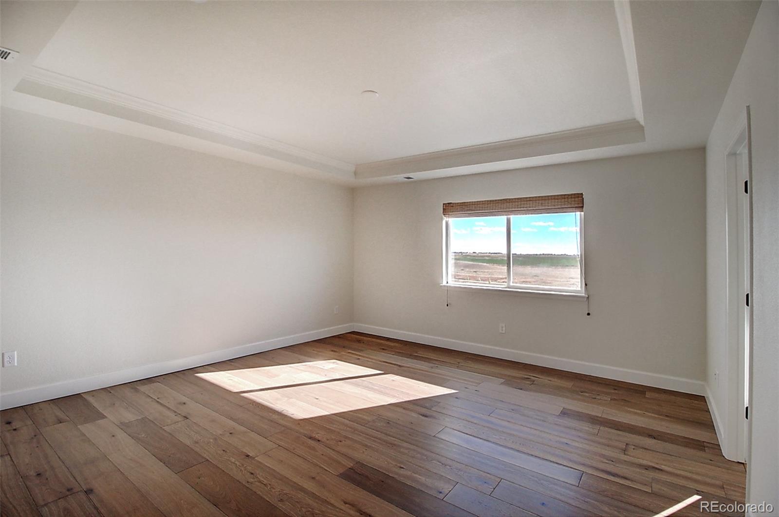 1013 Gabriella Lane Berthoud, CO 80513 - Photo 33 of 39 an empty room with wooden floor and windows