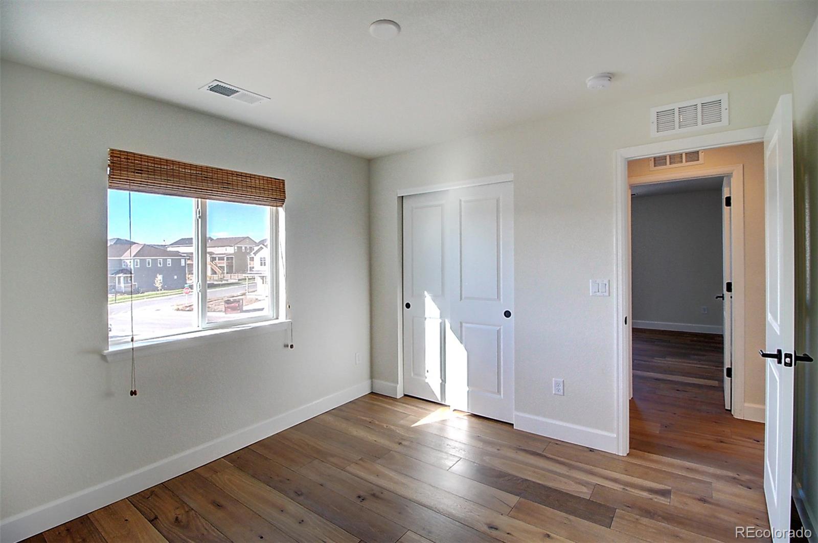 1013 Gabriella Lane Berthoud, CO 80513 - Photo 34 of 39 a view of an empty room with wooden floor and a window