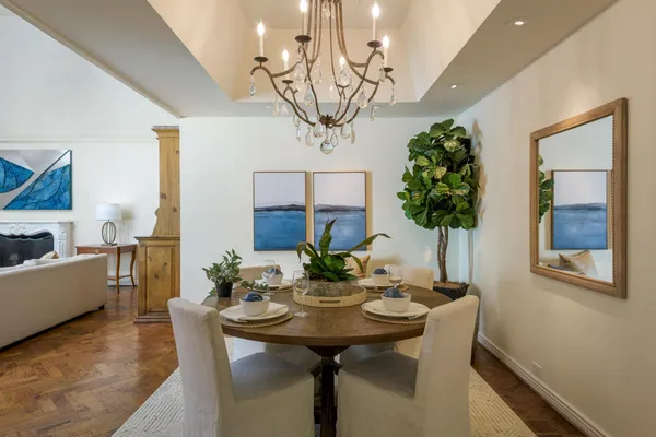 a view of a dining room with furniture a chandelier and wooden floor