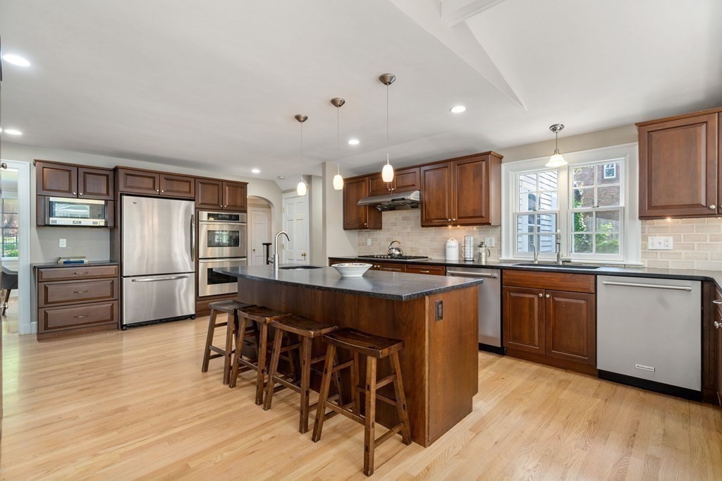 23 Ashford Road Newton, MA 02459 - Photo 3 of 35 a kitchen with stainless steel appliances granite countertop a refrigerator a sink dishwasher a stove and white countertops with wooden floor