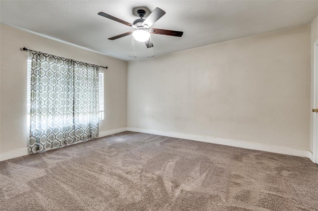 1015 Kings Highway Dallas, TX 75208 - Photo 11 of 15 an empty room with chandelier fan and windows