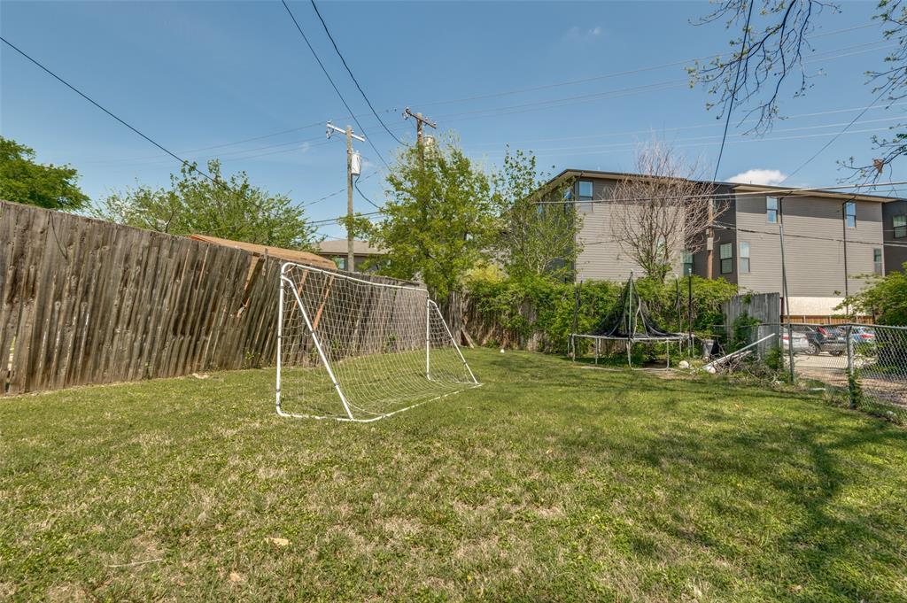 1015 Kings Highway Dallas, TX 75208 - Photo 12 of 15 a view of a backyard with a slide trees and wooden fence