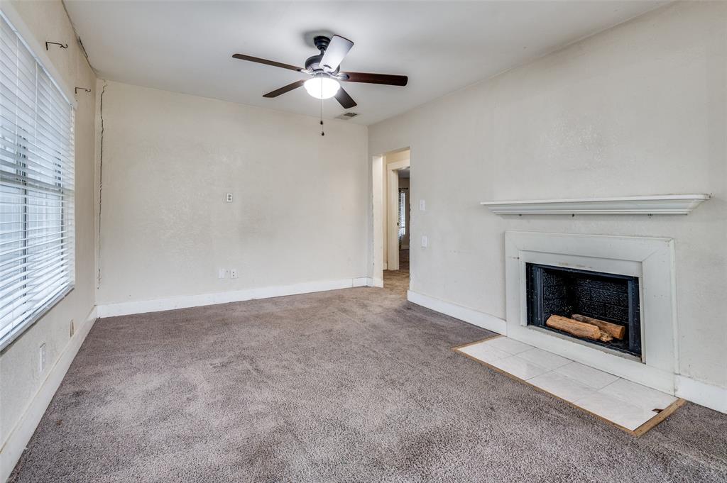 1015 Kings Highway Dallas, TX 75208 - Photo 4 of 15 an empty room with fireplace and fan