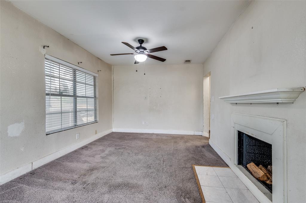 1015 Kings Highway Dallas, TX 75208 - Photo 5 of 15 a view of an empty room with a fireplace and a window