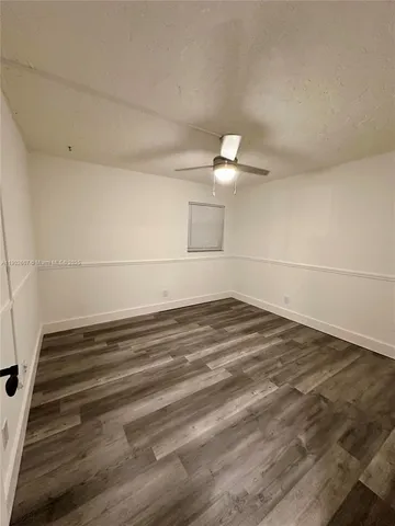 a view of a room with wooden floor and white walls