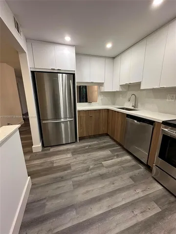 a kitchen with a refrigerator sink and cabinets