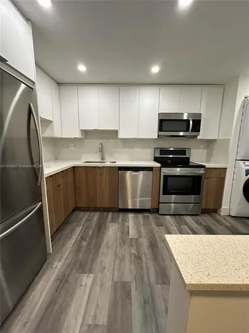 a kitchen with stainless steel appliances granite countertop a refrigerator and a stove top oven
