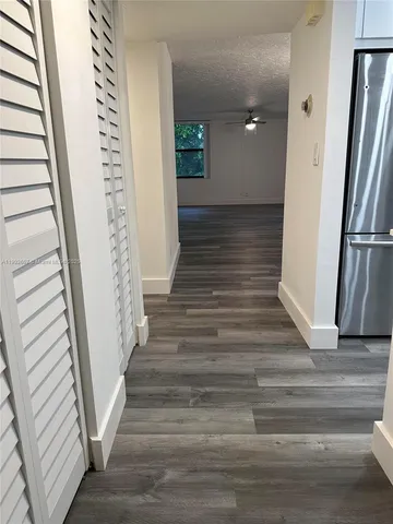 a view of a hallway with wooden floor and staircase