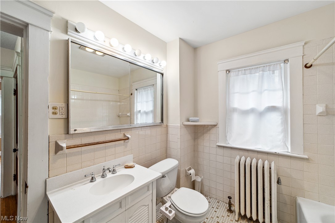 3045 East Overlook Road Cleveland, OH 44118 - Photo 15 of 29 Bathroom featuring vanity, radiator heating unit, toilet, tile walls, and tile floors