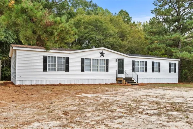 a house that has a big yard and large trees
