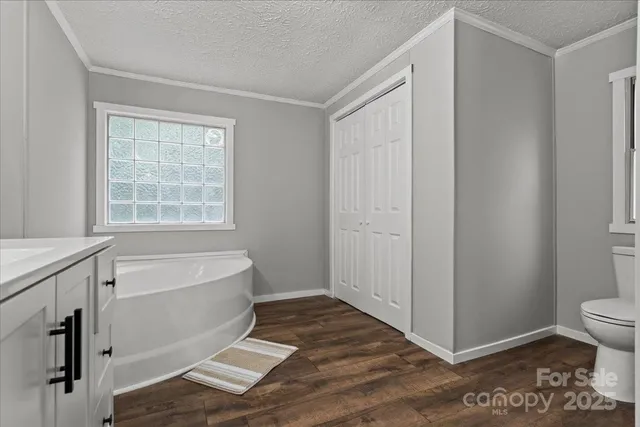 a bathroom with a bathtub a toilet and a window