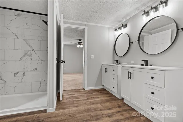 a bathroom with a double vanity sink mirror and shower