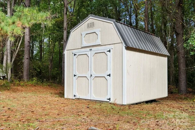 a view of a house with backyard and trees