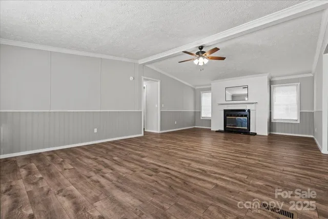 a view of empty room with wooden floor and fireplace